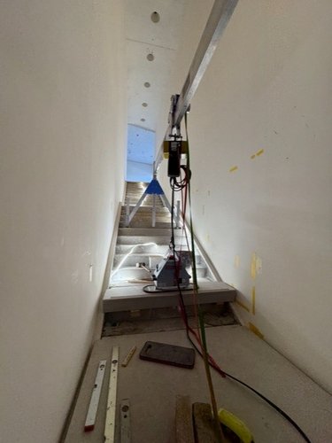 Sonderkran für beengte Platzverhältnisse | Aluminium-Portalkran Sonderlösung SCHILLING Aluminium-Sonderkran bei der Montage einer Treppe in engem Treppenhaus