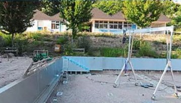 Alu-Portalkran von SCHILLING wird auf einer Baustelle im Freibad Tennenbronn eingesetzt, um Modernisierungsarbeiten an einer Schwimmbeckenumrandung durchzuführen.