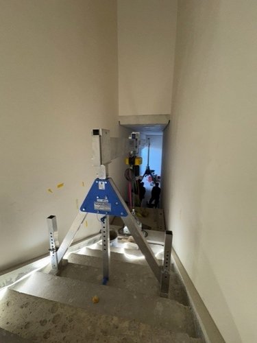 Sonderkran für beengte Platzverhältnisse | Aluminium-Portalkran Sonderlösung SCHILLING Aluminium-Sonderkran bei der Montage einer Treppe in engem Treppenhaus