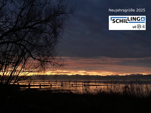 Dämmerungsstimmung über dem Bodensee mit dunklem Himmel, Sonnenuntergang am Horizont, Text: „Neujahrsgrüße 2025“ und Firmenlogo „SCHILLING we lift it“.